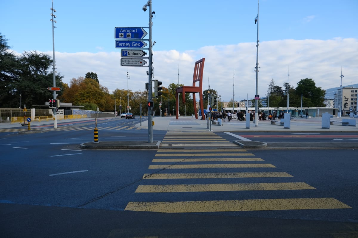 Place des Nations à Genève avec la sculpture Broken Chair, face à l'ONU, évoquant le droit des étrangers et les permis de séjour.